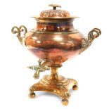 A Regency brass and copper twin handled tea urn, and cover with a floral finial, with brass tap, rai