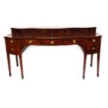 A 19thC flame mahogany serpentine sideboard, with raised top, three central drawers, and cellarette