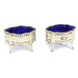 A pair of George V silver salts, of serpentine form, with pierced and engraved decoration, with blue