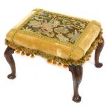 A Victorian walnut stool, with Neoclassical carved cabriole legs, upholstered in wool work and crush