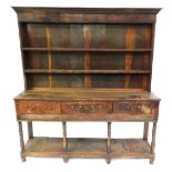 A Georgian oak dresser, with moulded top over plate rack, three frieze drawers, baluster turned legs