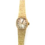 A Tissot 9ct gold cased lady's wristwatch, with a silvered watch head on a bark effect bracelet, 17c