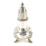 An Elizabeth II silver sugar shaker, with a pierced and fluted top, on tripod shell capped legs, Lon