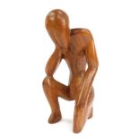 A carved wooden figure, of a person in seated pose, 35cm high.