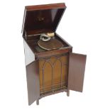 A His Master's Voice oak cased cabinet gramophone, model number 136, with a hinged lid opening to re