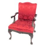 A 19thC mahogany open armchair, with red damask upholstery, carved and scroll arms, and cabriole leg
