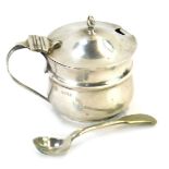 A George V silver mustard pot, with acorn finial top and swing handle, Birmingham 1926, with blue gl