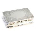 A George VI silver snuff box, of serpentine form, with foliate engraving, central vacant shield rese