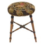 A Victorian walnut stool, with turned framing and wool work top, 43cm diameter.