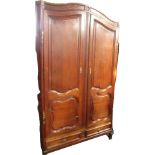 A late 19thC French oak armoire, domed pediment over a pair of panelled doors, over two frieze drawe