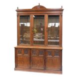 A late Victorian oak cabinet bookcase, with fan arch pediment, over moulded and plain frieze, with t