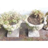 A pair of reconstituted stone garden planters, each with leaf moulded body, on square foot, 46cm hig