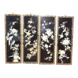 A set of four modern Japanese lacquer panels, each raised with mother of pearl finish flowers, with