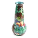 A 20thC FX Abraham, Hancock and Sons pottery vase, decorated with fruit, on a brown and green ground