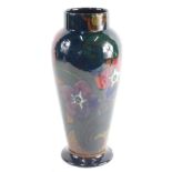 A 20thC Decoro pottery vase, typically decorated with flowers, on an opalescent green ground, printe