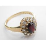 A 9ct gold dress ring, with central oval cut garnet surrounded by CZ stones, ring size M, 2.3g all i