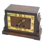 A mid 20thC Art Deco oak cased mantel clock, with brass pierced numerals, with stepped sides, on rec
