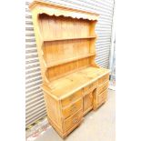 A pine kitchen dresser, with plate rack above cupboards.