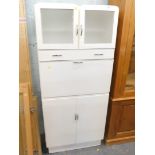 A vintage 1950s kitchen cabinet, with frosted glass doors.