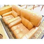 A tan leather three piece lounge suite, comprising three seater settee and two armchairs.