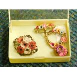 A small group of floral jewellery, with applied clay flower detailing, comprising two brooches and a