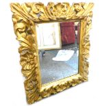 A 20thC gilt wood mirror, set with scrolls and shells, 72cm x 60cm.