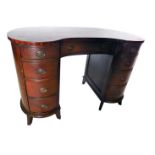 A mahogany kidney shaped desk or dressing table, with an arrangement of nine drawers, each with oval