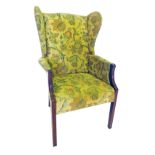 A winged back chair, in tapestry upholstery, with square mahogany legs.