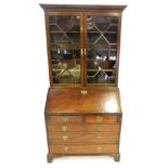 A George III figured mahogany bureau bookcase, the upper cabinet with two astragal glazed doors, wit