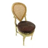 A 19thC Continental white painted music stool or chair, the teardrop shaped caned back on scrolling