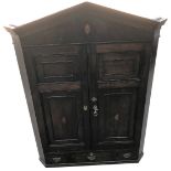 A George III oak hanging corner cupboard, with arched top, shell inlays, two doors and drawer, 128cm