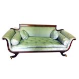 A Regency style mahogany sofa, in green upholstery, with straight reeded upper rail, scroll arms, ra