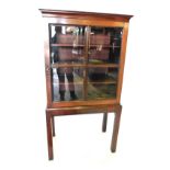 A mahogany display cabinet or bookcase in George III style, with a moulded cornice above a single as