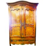 A 19thC French provincial walnut armoire, with swept moulded cornice, the carved frieze with a baske