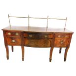 A Regency mahogany and ebony strung sideboard, with a brass gallery, a reeded edge and a bow fronted