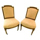 A pair of late 19thC gilt salon type chairs, each with a ribbon carved frame, a pink striped padded