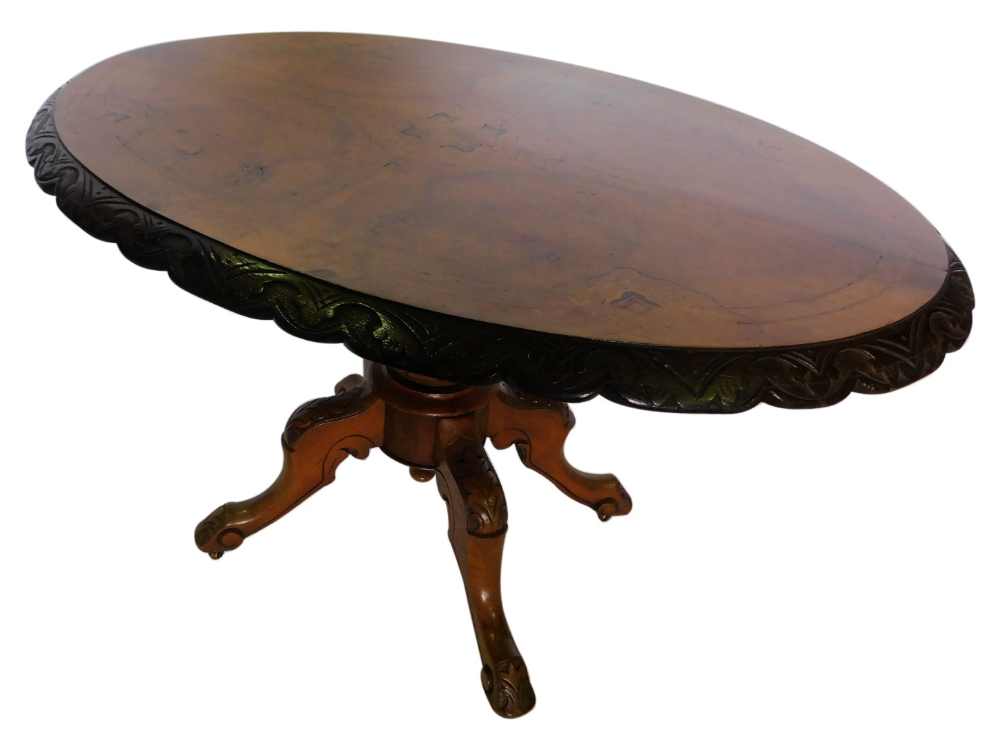 A Victorian walnut and marquetry oval loo table, the top with a carved shaped border, on a turned co
