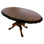 A Victorian walnut and marquetry oval loo table, the top with a carved shaped border, on a turned co