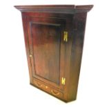 An early 19thC oak hanging corner cabinet, with a panelled door and a drawer, 113cm high, 89cm wide.