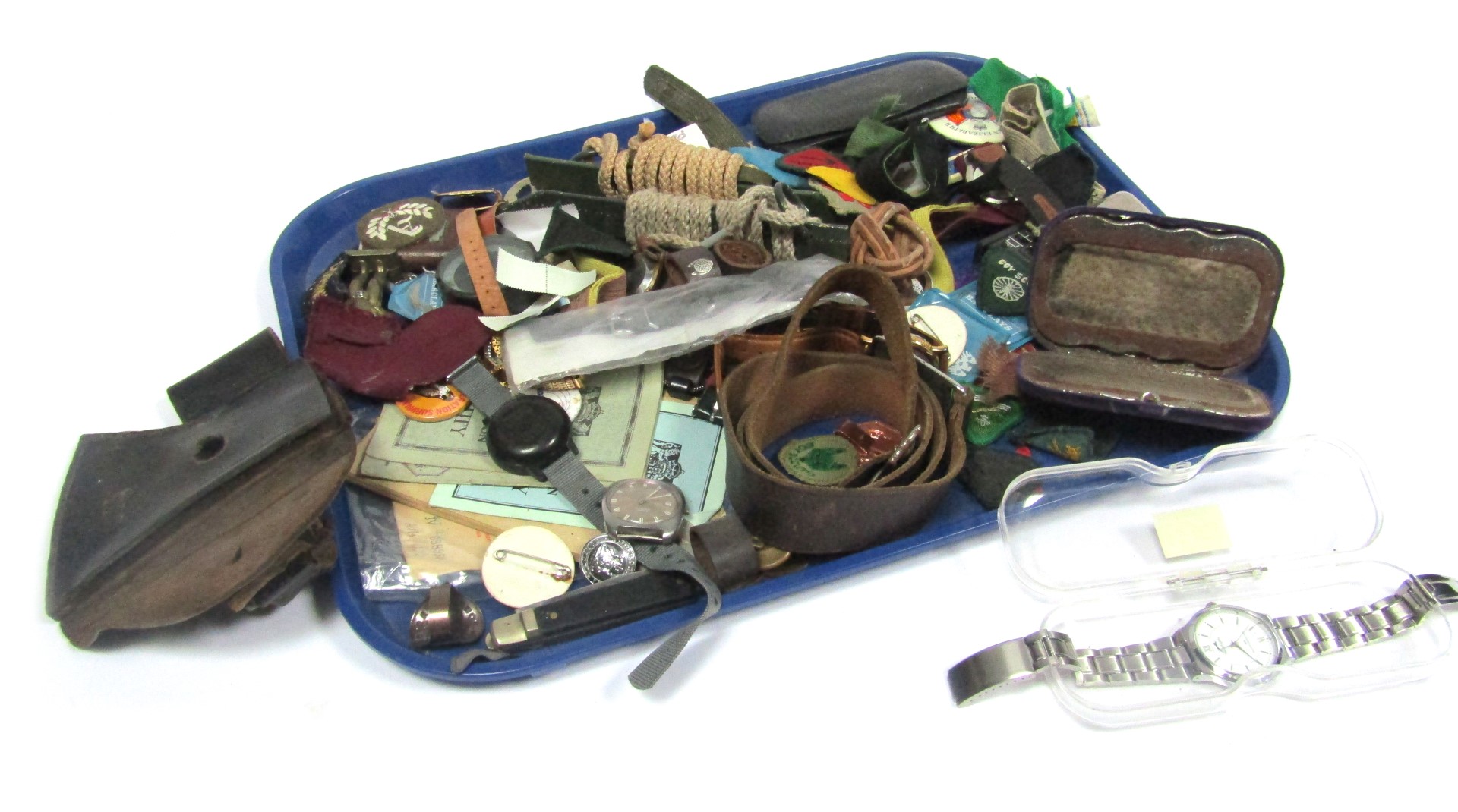 A mixed group of trinkets, including watch heads, coins, cap badges, and a small selection of scout