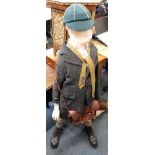A small child mannequin, dressed in wartime style clothing.
