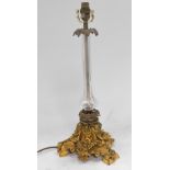 A Victorian cut glass and brass candlestick, converted to a table lamp, raised on a gilt brass base,