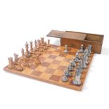 A late 19thC copper and pewter chess set, King 10cm high, boxed, together with a wooden chess board,