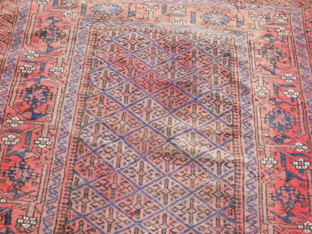 A Caucasian red ground runner, with a central floral geometric rectangular field, within repeating f - Image 2 of 3