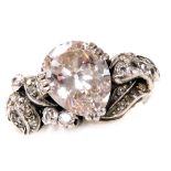 An Art Deco diamond and platinum ring, the central pear shaped diamond claw set at an angle with scr