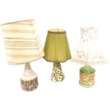 Three mid century pottery table lamps, comprising a floral encrusted lamp with a green frilled shade