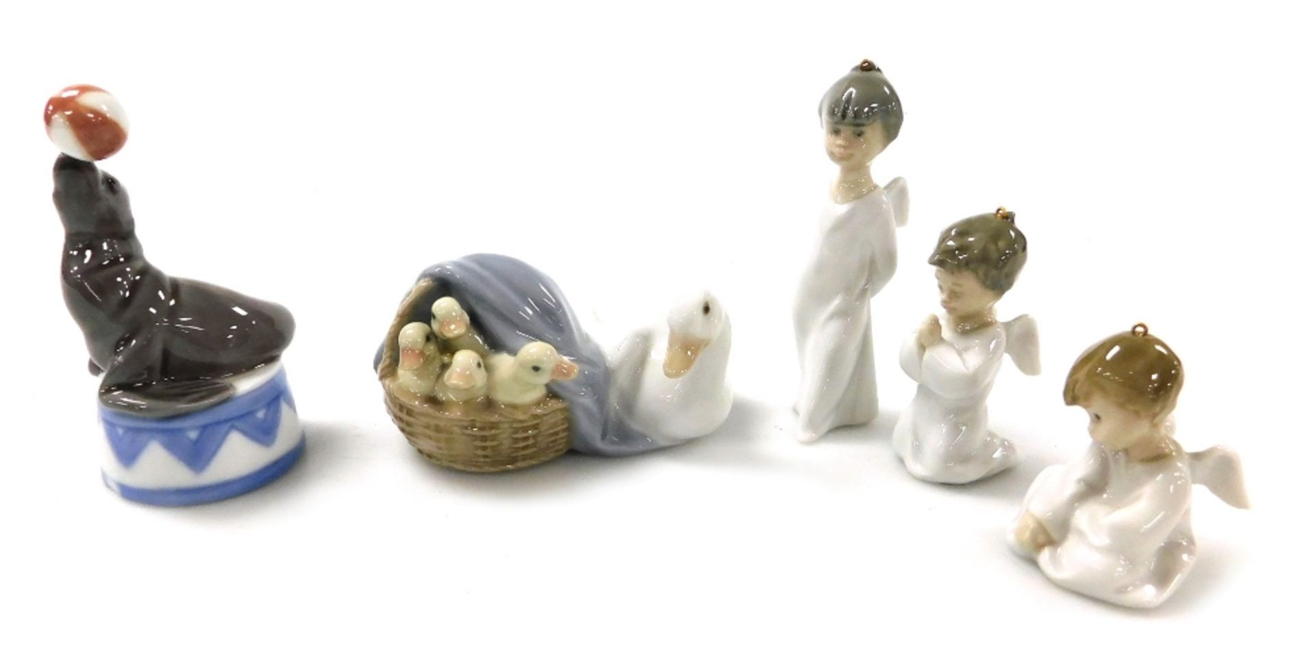 Three Lladro porcelain cherub Christmas ornaments, a Lladro porcelain figure of a seal with a ball,