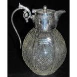 A Victorian cut glass claret jug, with silver mount, spout, and scrolling handle, with a hinged lid,