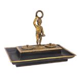 A late 19thC French bronze and brass encrier, of rectangular form, with a central carrying figure of