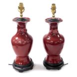 A pair of Chinese sang-de-boeuf vase form table lamps, of baluster form, with fruit moulded handles,